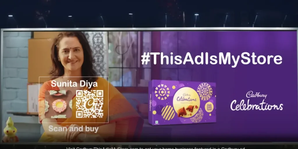 A Cadbury Celebration billboard with a transparent QR Code, logo, and a lady promoting her Diya collection with a "Scan and Buy" CTA.