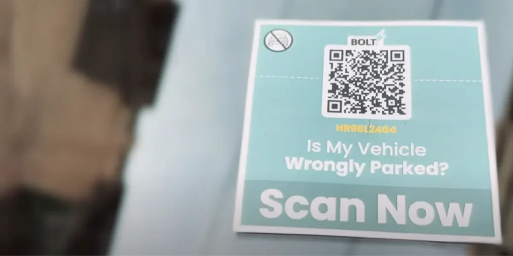 A black-and-white QR Code by Roadcast with "Is my vehicle wrongly parked?" and a "Scan Now" CTA to connect with the owner.