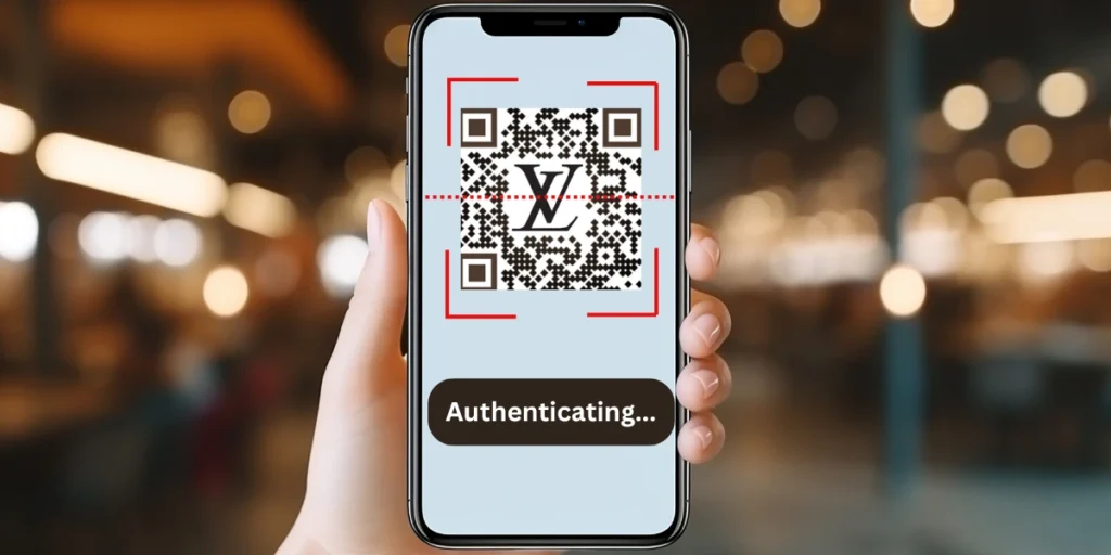 Hand holding a smartphone scanning an Louis Vuitton QR code for authentication, with an 'Authenticating' message displayed.