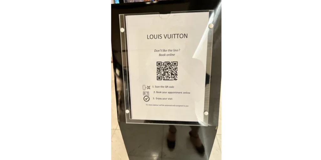 Louis Vuitton QR code sign for booking appointments online, offering an option to skip the line in-store.